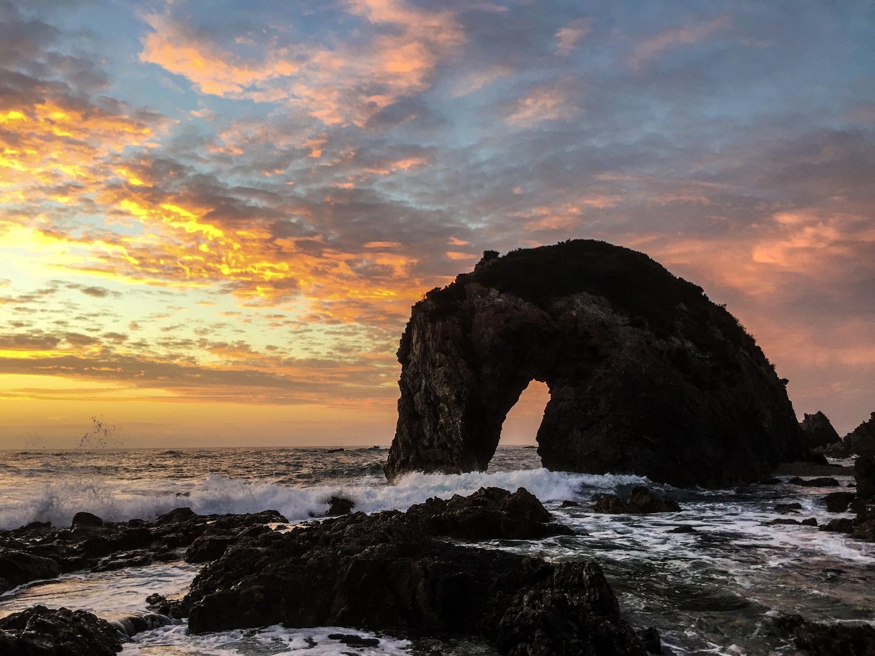 Sunset over coastal sea arch — Horse Head Rock, NSW